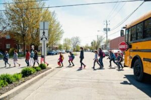 Kids in line crossing street getting out of school bus